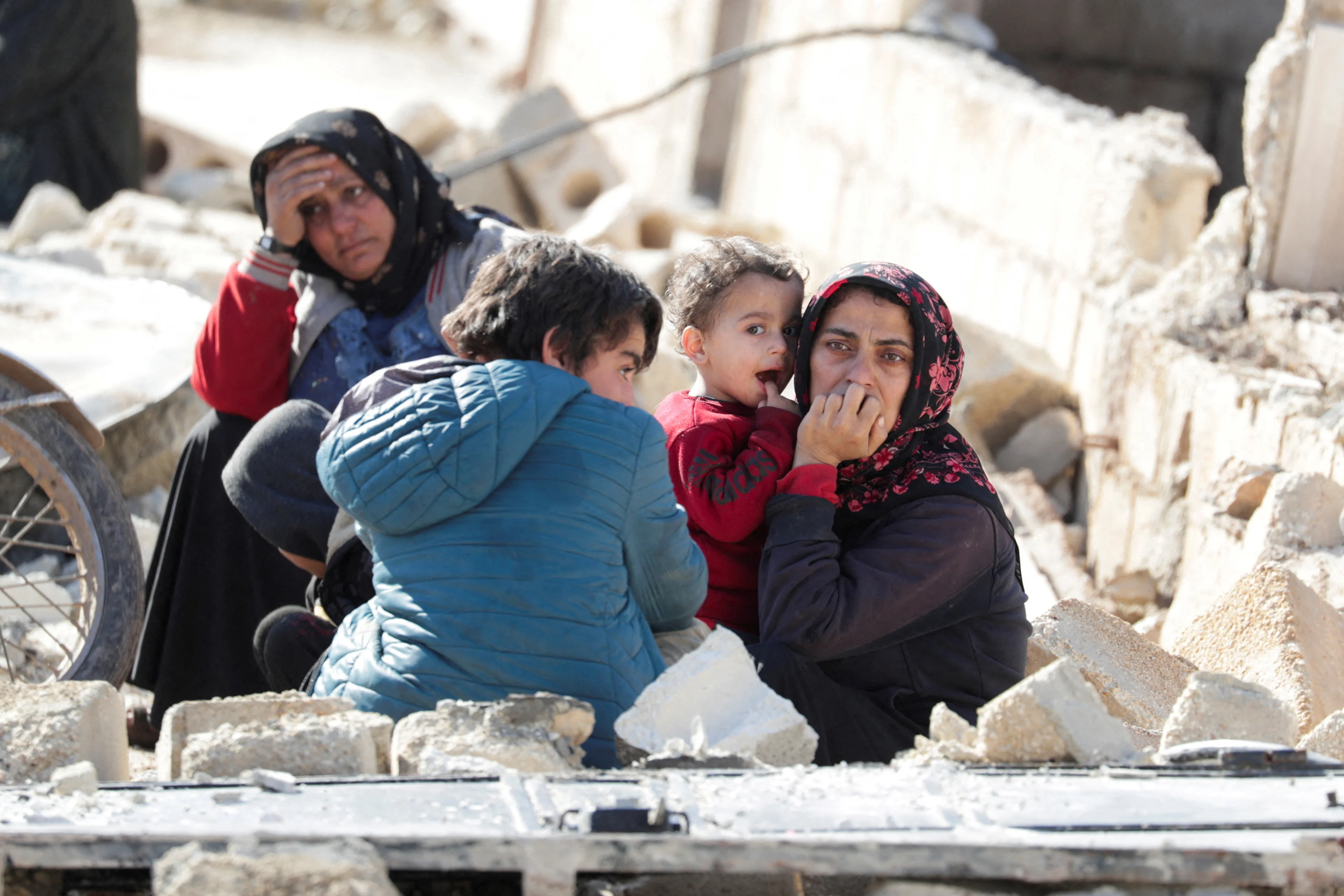 People sitting on the rubble react in the aftermath of an earthquake, in rebel-held town of Jandaris, Syria February 7, 2023. REUTERS/Khalil Ashawi