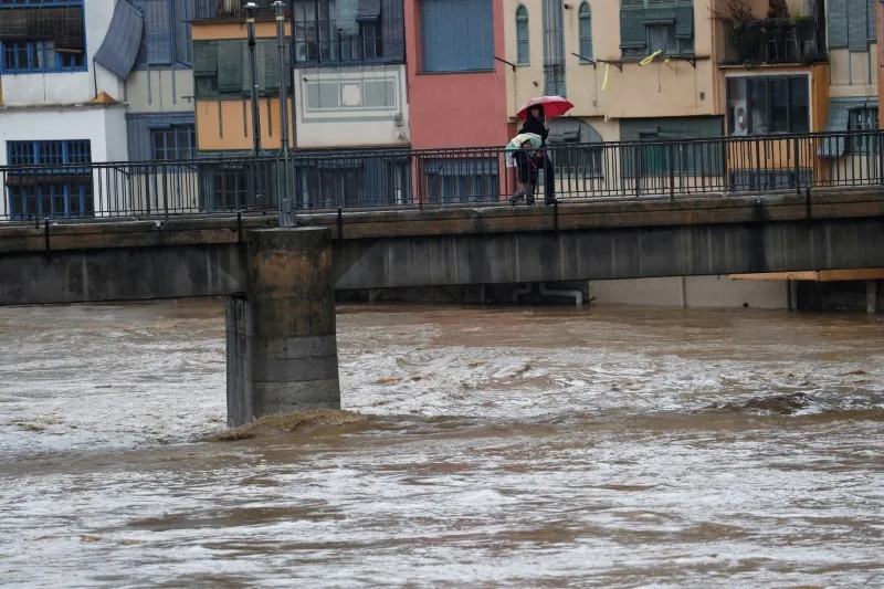 REUTERS: Residents walk on a bridge on the Onyar river during the storm "Gloria" in Girona, Spain, January 22, 2020. REUTERS/Nacho Doce