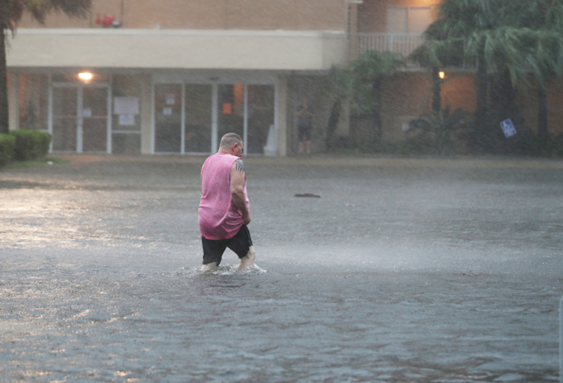 GETTY IMAGES: GULF SHORES, ALABAMA - SEPTEMBER 15: A man walks though a flooded parking lot as the outer bands of Hurricane Sally come ashore on September 15, 2020 in Gulf Shores, Alabama. The storm is bringing heavy rain, high winds and a dangerous storm surge from Louisiana to Florida. (Photo by Joe Raedle/Getty Images)