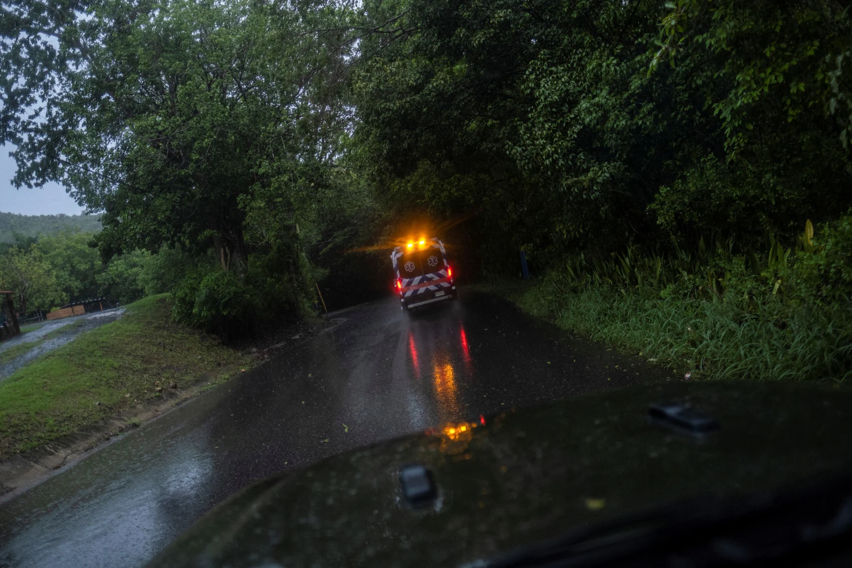 An ambulance drives through a wet rural road as Hurricane Fiona and its heavy rains approaches in Guayanilla, Puerto Rico September 18, 2022. (REUTERS/Ricardo Arduengo)