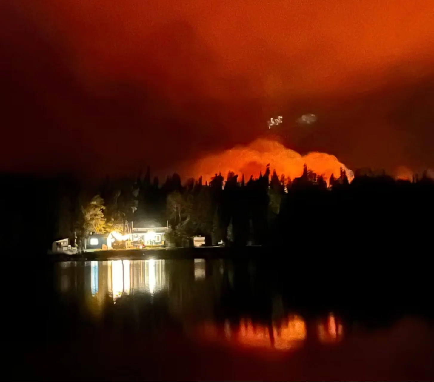 CBC: A fire near Sherridon is seen earlier this week across a lake. (Johnny Patterson/Facebook)