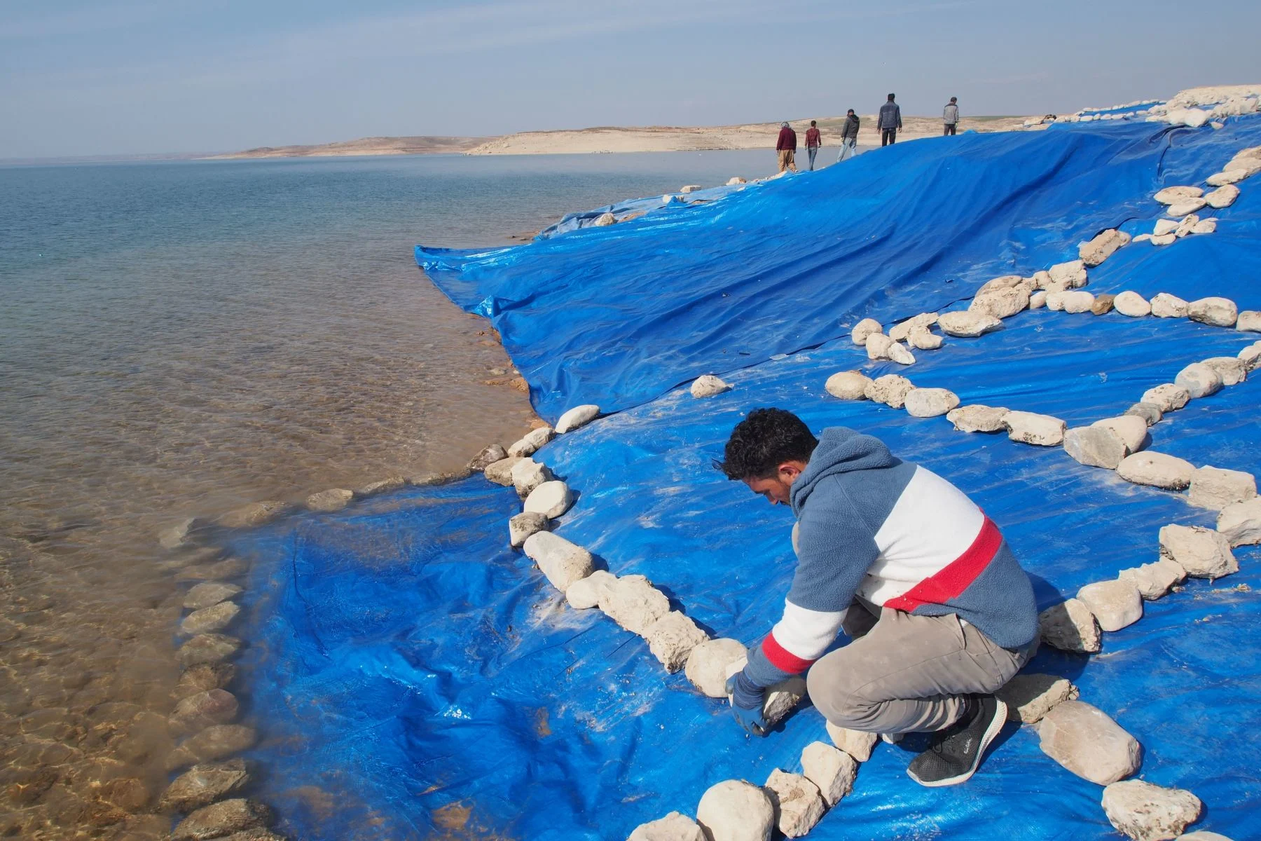 After the research team has completed their work, the excavation is covered extensively with plastic foil to protect it from the rising waters of the Mosul reservoir. (Universities of Freiburg and Tübingen, KAO)