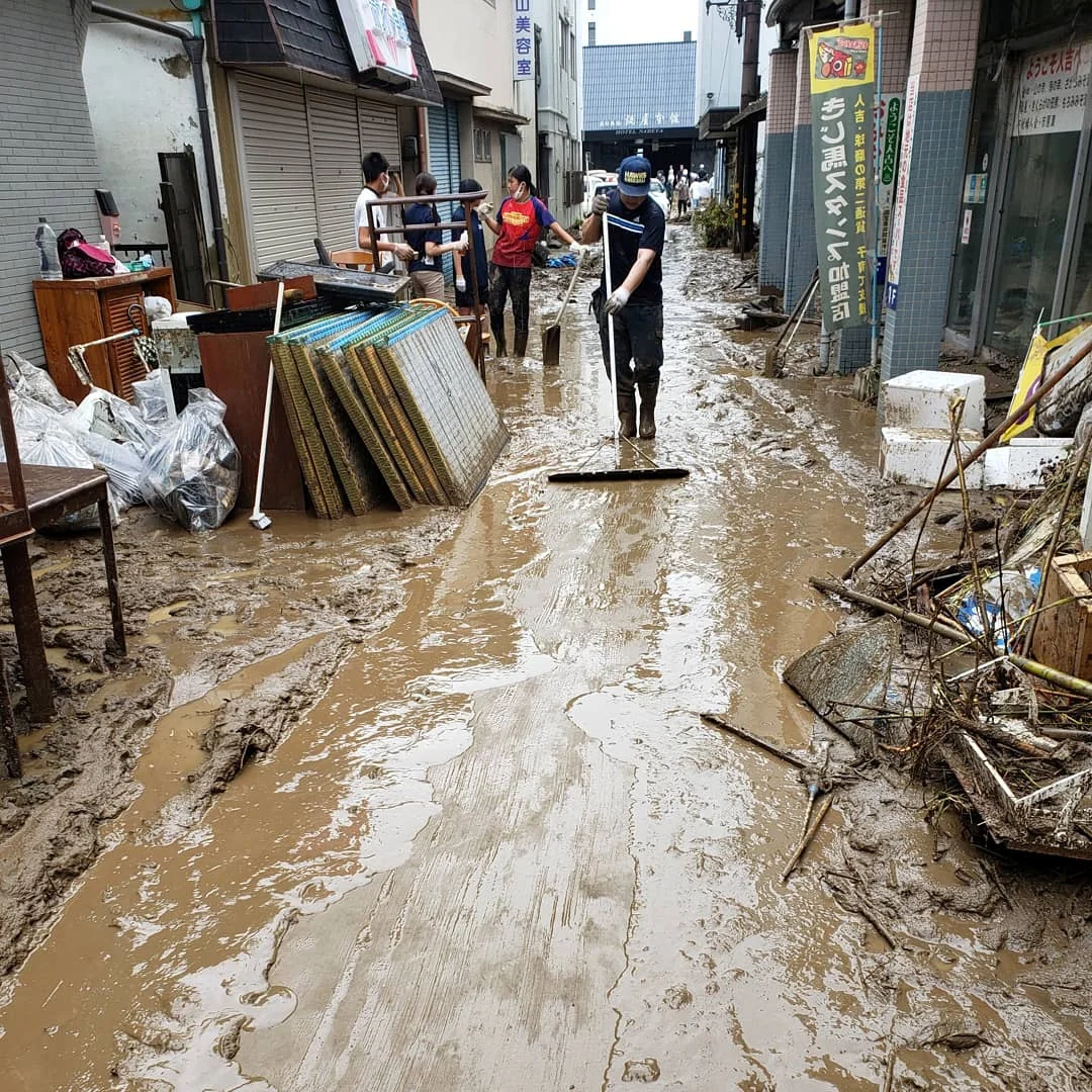 REUTERS: People clean a muddy street after heavy rains in Hitoyoshi, Kumamoto prefecture, Japan, July 5, 2020, in this picture obtained from social media. Picture taken July 5, 2020. TWITTER @NEOTIGER2010/via REUTERS THIS IMAGE HAS BEEN SUPPLIED BY A THIRD PARTY. MANDATORY CREDIT. NO RESALES. NO ARCHIVES.