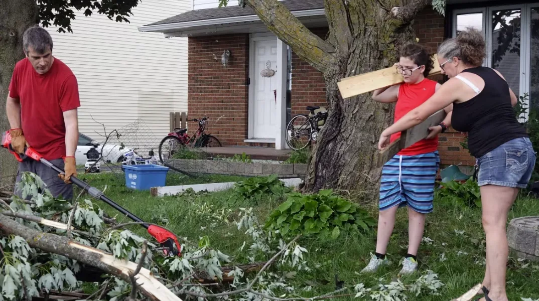 CBC: Jakeb Tucker and his aunt Angela Lake help clean up branches torn down by the tornado. (Dan Taekema/CBC)