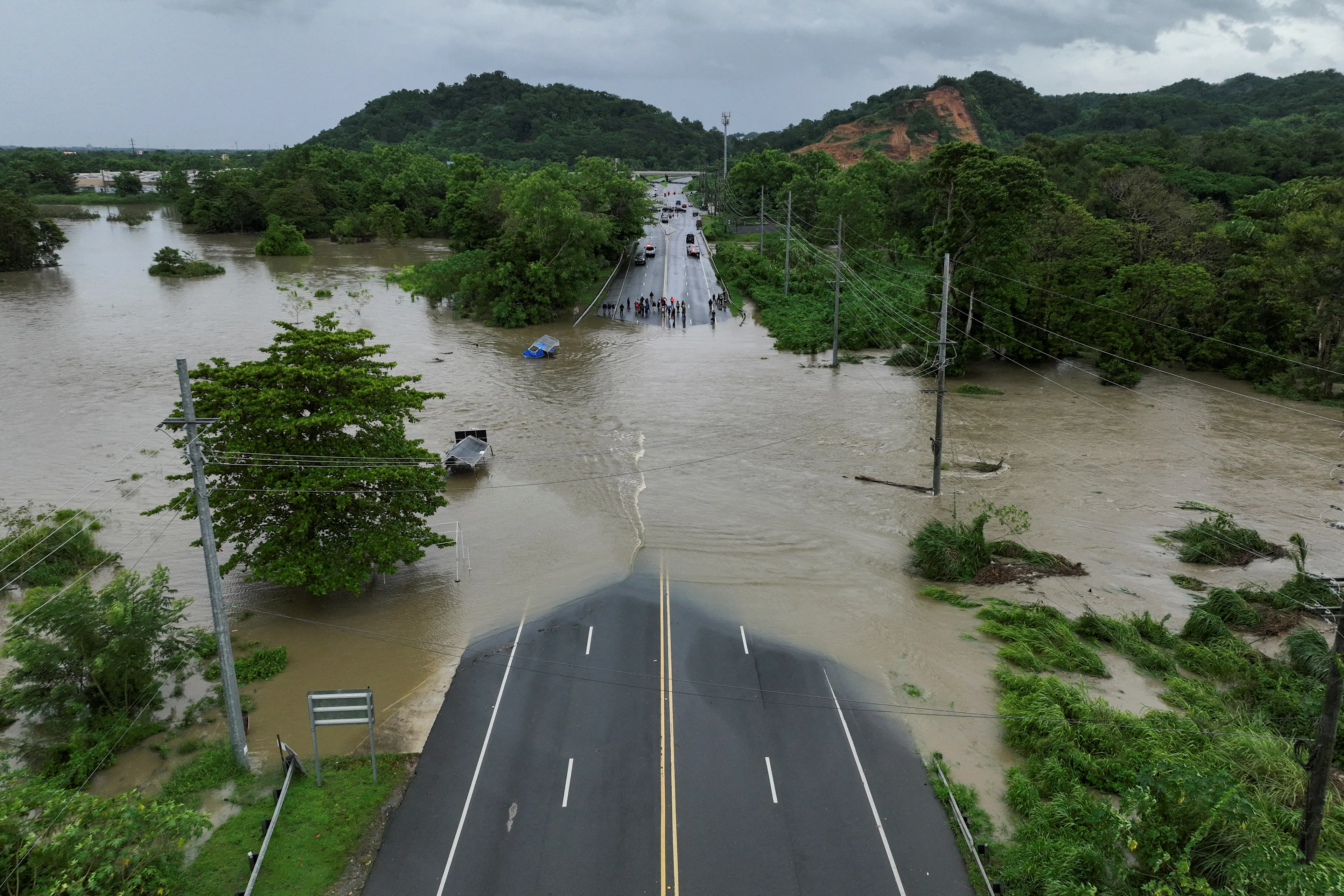 REUTERS: A drone view shows a bridge submerged by the flooded La Plata River in the aftermath of Tropical Storm Ernesto in Toa Baja, Puerto Rico August 14, 2024. REUTERS/Ricardo Arduengo