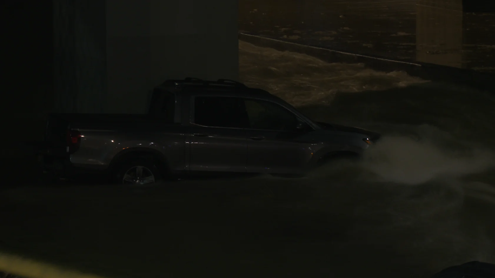 Truck stuck in rushing floodwater on Calgary highway on Dec. 31, 2025. (Connor O'Donovan/TWN)