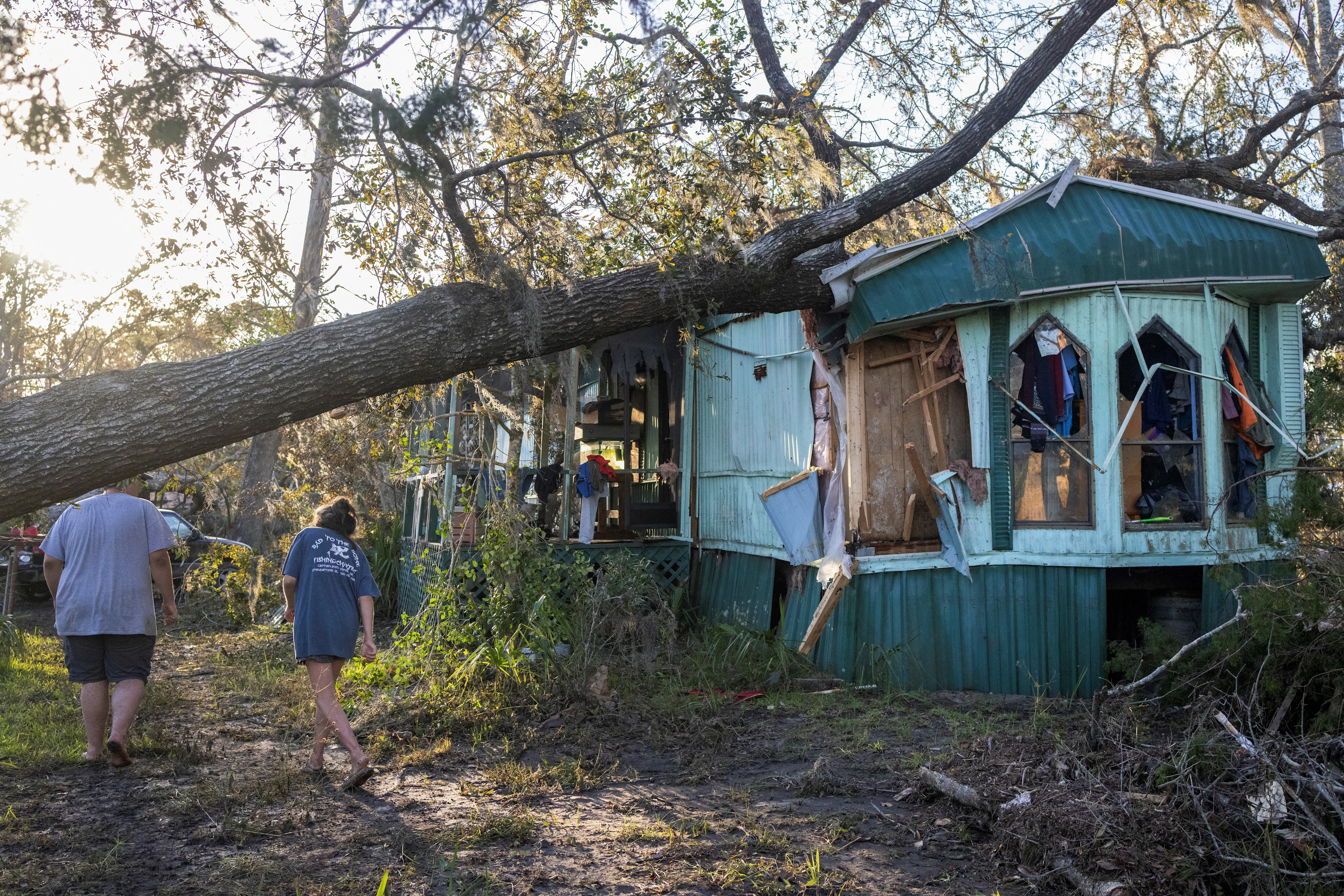 REUTERS: Nash Harris and his mother Alicia walk towards the home where they had been living to try and find some salvageable clothing after Hurricane Helene made landfall in Steinhatchee, Florida, U.S., September 27, 2024. REUTERS/Kathleen Flynn