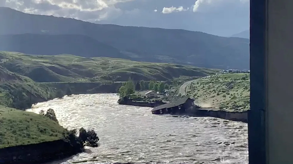 REUTERS: A house falls into the Yellowstone river due to flooding in Gardiner, Montana, U.S., June 13, 2022 in this screen grab obtained from a social media video. Angie Lilly/via REUTERS