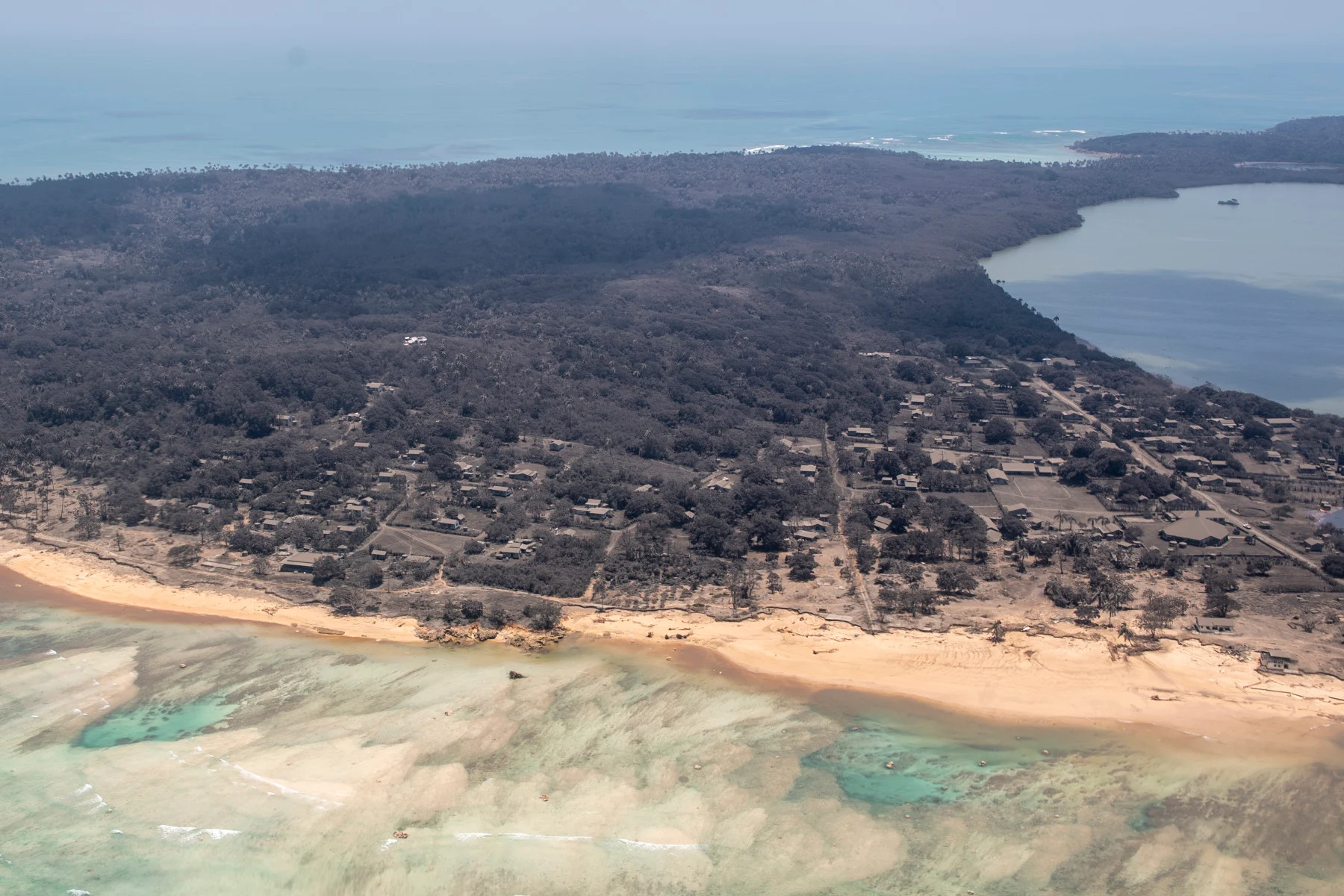 A P-3K2 Orion aircraft flying over an area of Tonga on January 17, 2022. Heavy ashfall from the recent volcanic eruption is visible within the Tongan Islands. (NZ Defence Force)