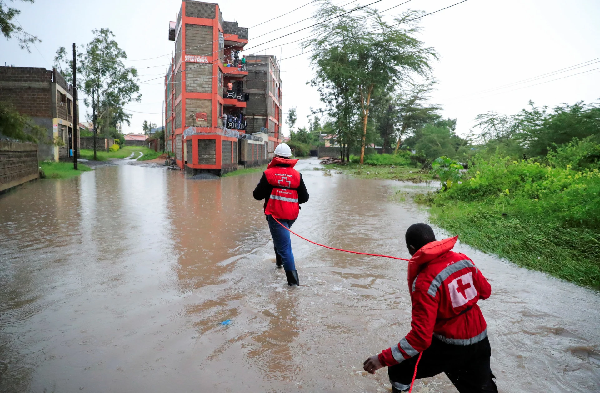 Reuters: Kenya Red Cross members hold on to a safety rope as they wade through flood waters to assess and rescue residents trapped in their homes marooned after a seasonal river burst its banks REUTERS/Thomas Mukoya