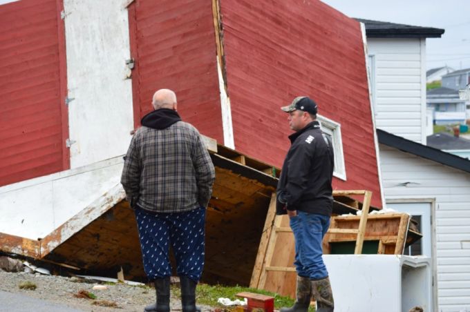 Two men in Port aux Basques survey the devastation of their town. More than 20 homes were destroyed completely, while others suffered catastrophic damage. (Malone Mullin/CBC)
