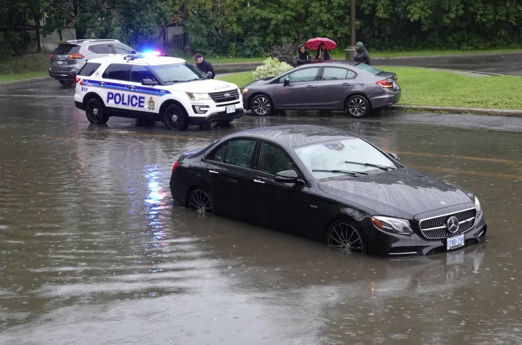 CBC: A car submerged by rain-related flooding on Kilborn Avenue on Aug. 10, 2023. (Giacomo Panico/CBC)