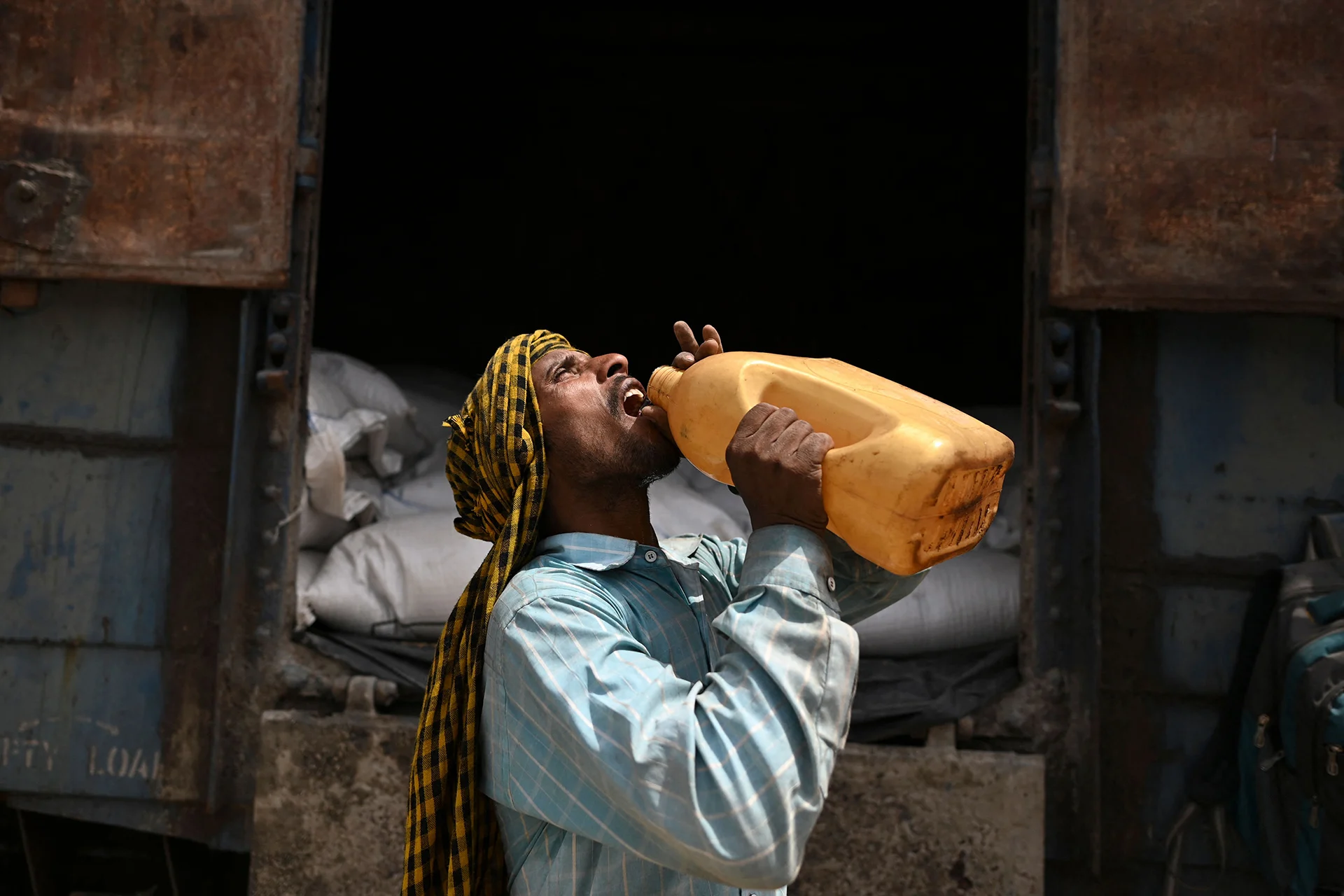A worker drinks water during a break from loading sacks of wheat on a freight train at Chawa Pail railway station in Khanna, Punjab state, India on May 19, 2022. The world's second-largest producer of wheat, on May 14 announced it would ban exports without special authorization from the government in the face of falling production caused primarily by an extreme heat wave. (Sajjad Hussain/ AFP/ Getty Images)