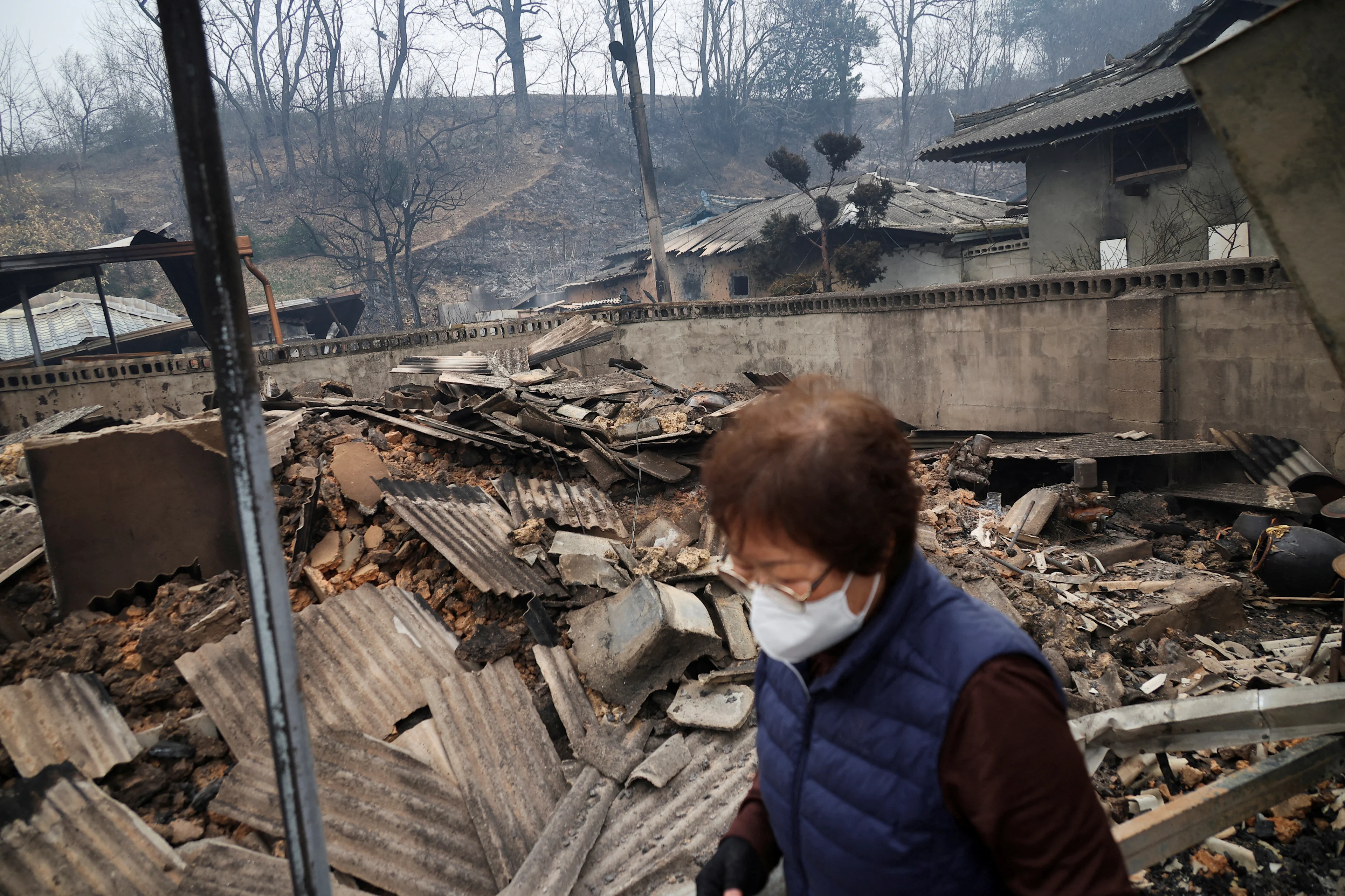REUTERS: Kun Yeong-nam, 72, walks at her burnt house, where she lived for 52 years, after a wildfire devastated the area in Uiseong, South Korea March 27, 2025.REUTERS/Kim Hong-Ji