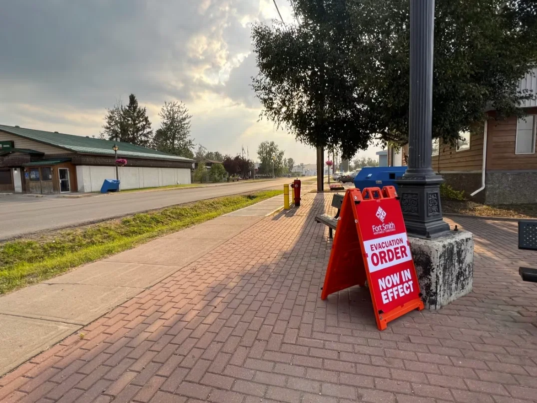CBC: An evacuation sign in Fort Smith, N.W.T. Firefighters were going door-to-door on Saturday to inform people of the order. (Carla Ulrich/CBC)
