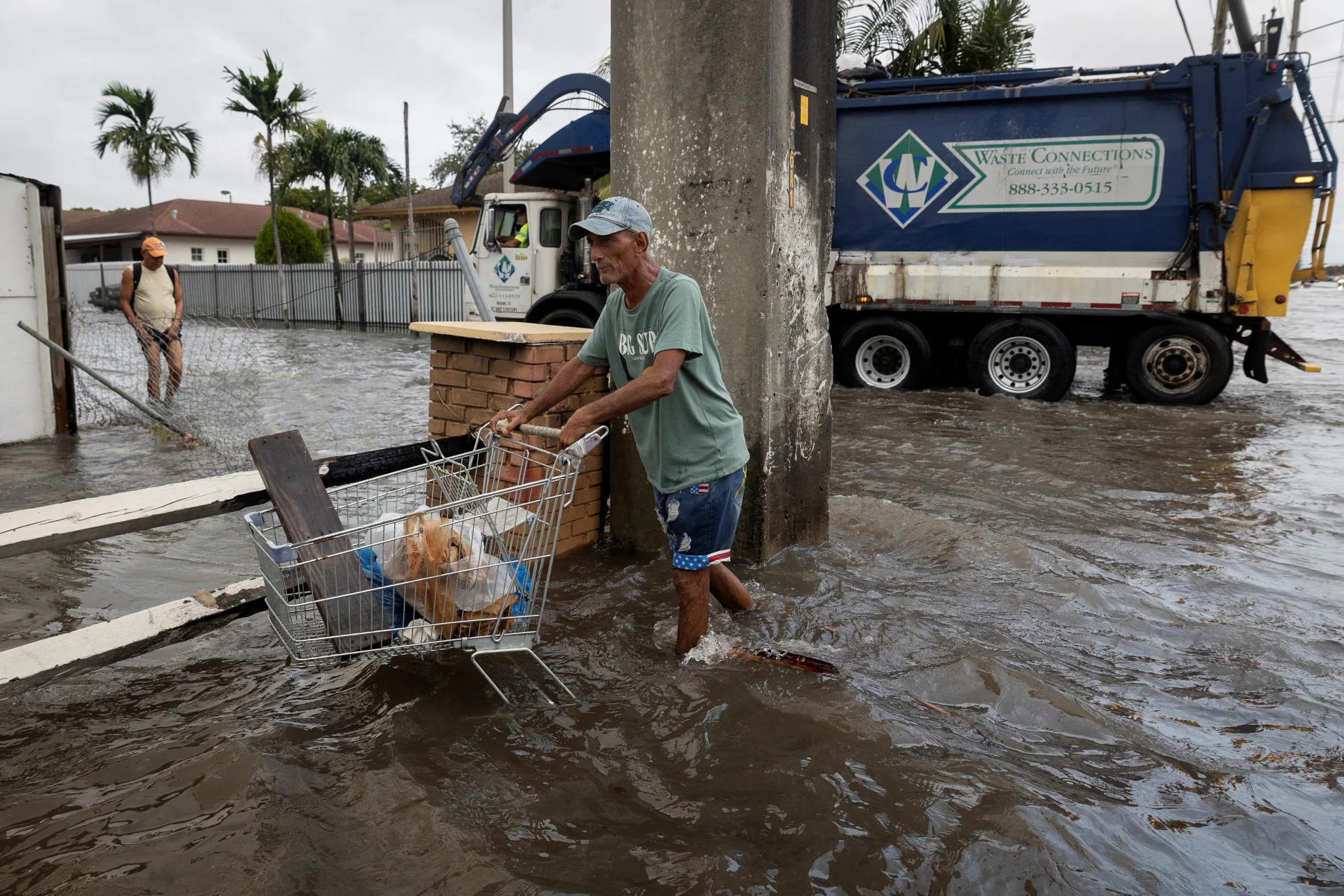 Reuters: A man pushes a cart as he walks in a flooded street in Hialeah, Florida, U.S., November 16, 2023. REUTERS/Marco Bello