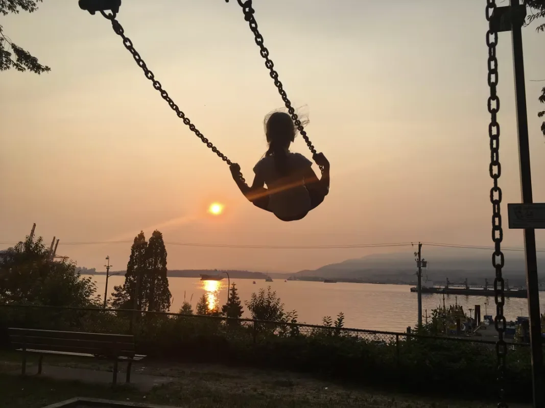 CBC: A child swings at a park in East Vancouver against smoky skies on Sept. 5, 2017. The extreme wildfire season in B.C. that summer prompted changes to how the AQHI was calculated in that province. (Lisa Johnson/CBC)