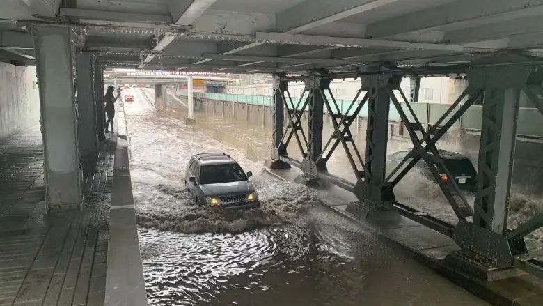 CBC: Car driving through flooding in Calgary (Julian Brown/CBC)