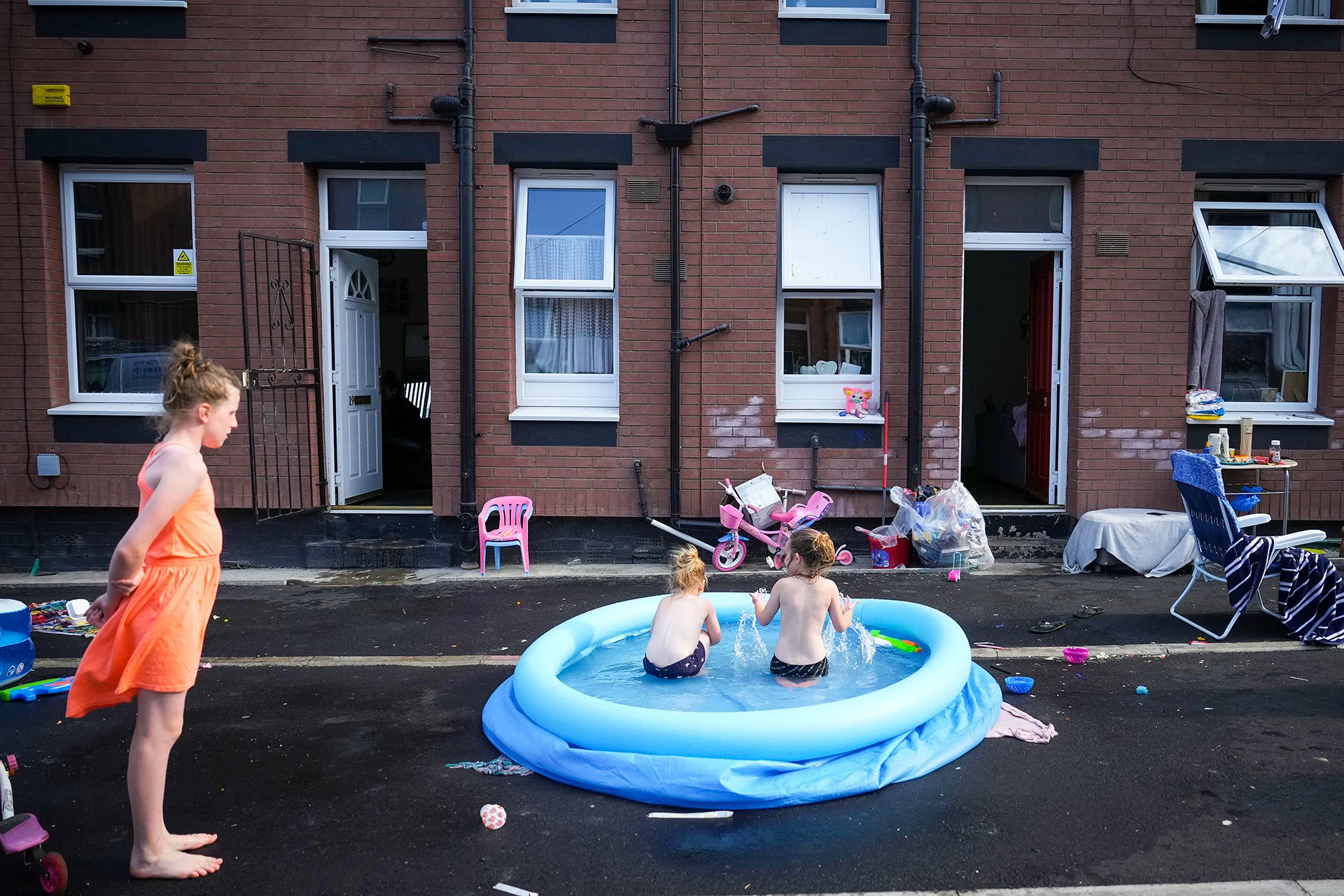 A family enjoys a barbecue and cool off in a paddling pool outside their home on July 19, 2022 in Leeds, United Kingdom. Temperatures exceeded 40 C in parts of England this day after the Met Office issued its first red extreme heat warning. Record-breaking temperatures were reached across the UK. (Christopher Furlong/ Getty Images)