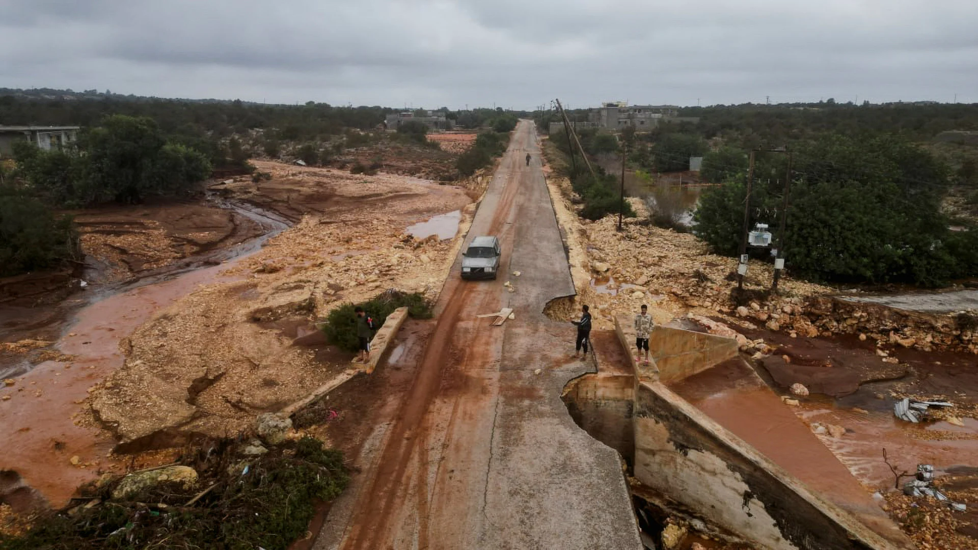 REUTERS: People stand in a damaged road as a powerful storm and heavy rainfall hit Shahhat city, Libya, September 11, 2023. REUTERS/Ali Al-Saad