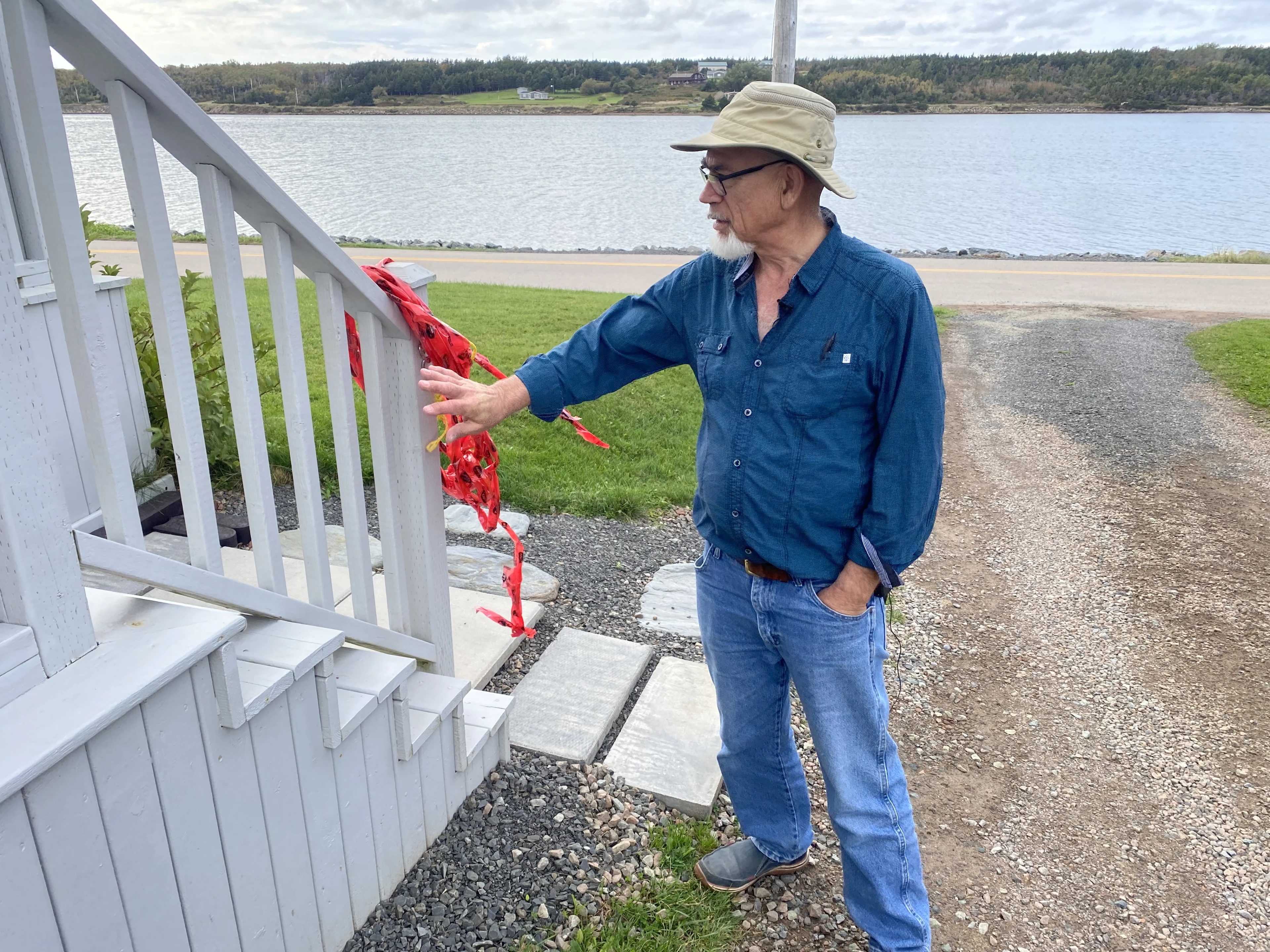 Nathan Coleman: Michel Soucy outside his home in Cheticamp, Nova Scotia, showing the rope he uses to get to his garage during Les Suetes wind events.