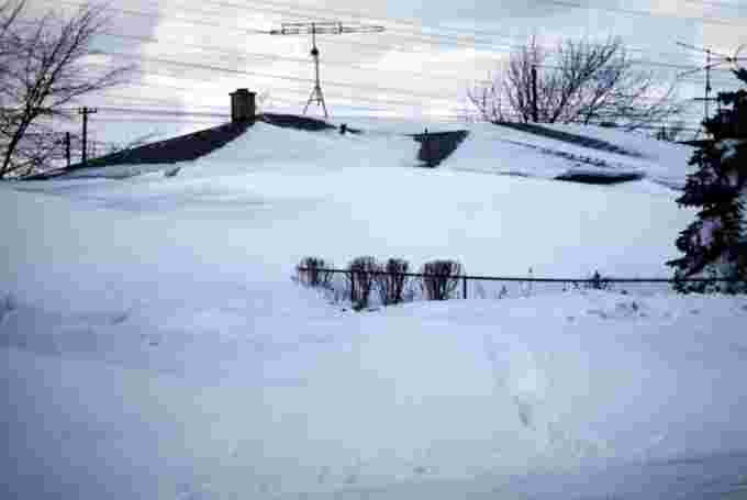A house almost completely buried in snow in Tonawanda, New York (January 30, 1977)