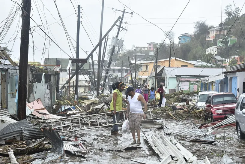 A road in the Roseau area of Dominica is littered with structural debris, damaged vegetation, and downed power poles and lines after Hurricane Maria in 2017. (Roosevelt Skerrit/ Wikimedia Commons)
