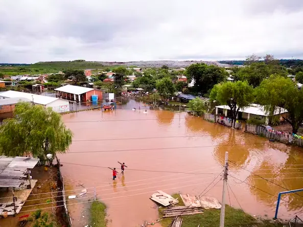 Men carrying boards wade on a flooded soccer field in the Jukyty neighbourhood of Asuncion, Paraguay, on April 4, 2019. More than 20,000 people were evacuated after torrential rains caused extensive flooding. (AP Photo/Jorge Saenz)