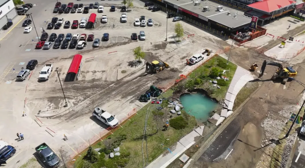 CBC: A drone shot of the spot where the catastrophic water main rupture broke ground, next to a plaza on 16 Ave. N.W., just west of Home Road. (Monty Kruger/CBC)