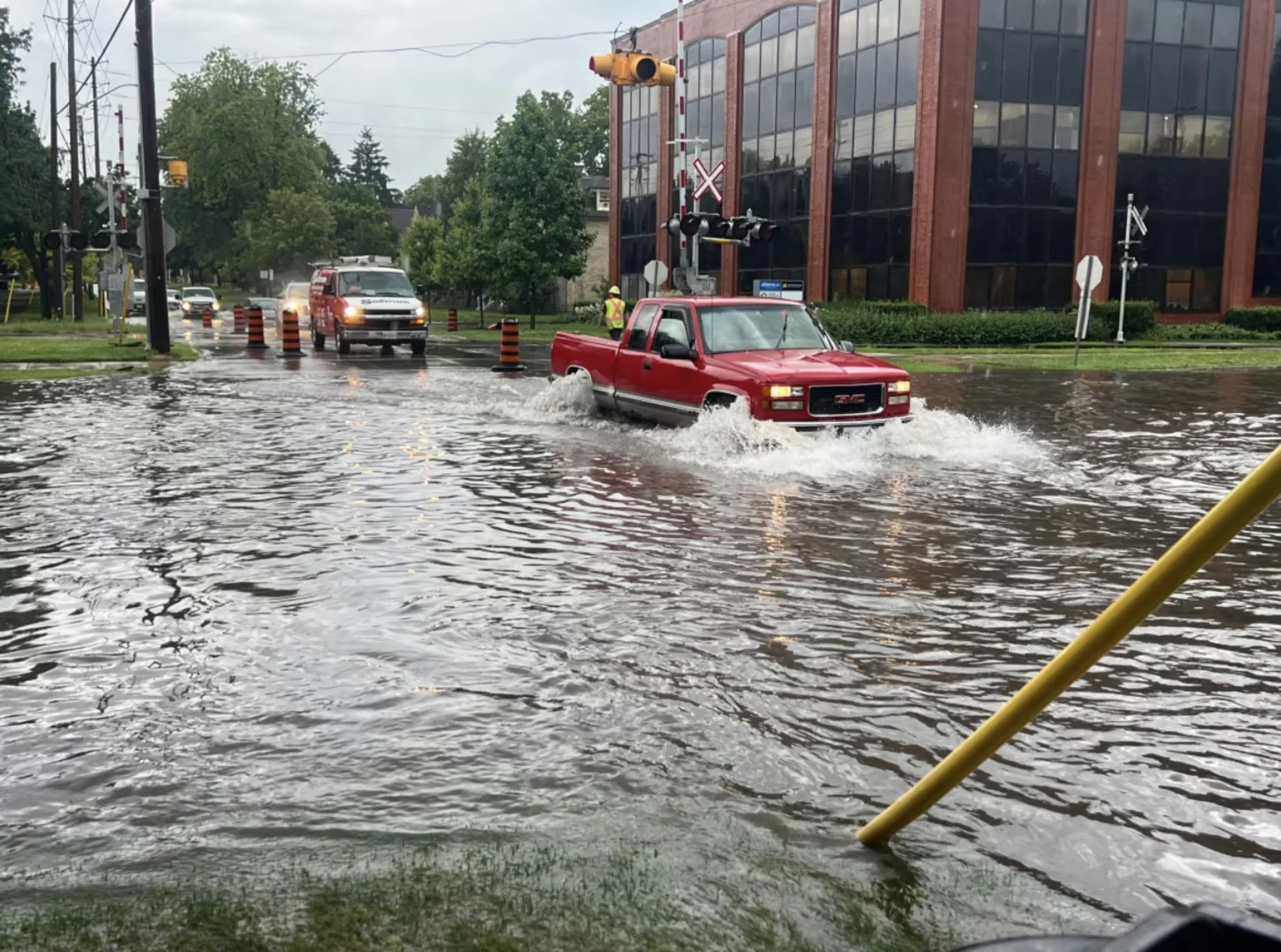 CBC: Drivers navigate through the flooded intersection of Waterloo Street and Pall Mall Street in London, Ont., on Monday, July 15, 2024. (Andrew Lupton/CBC)