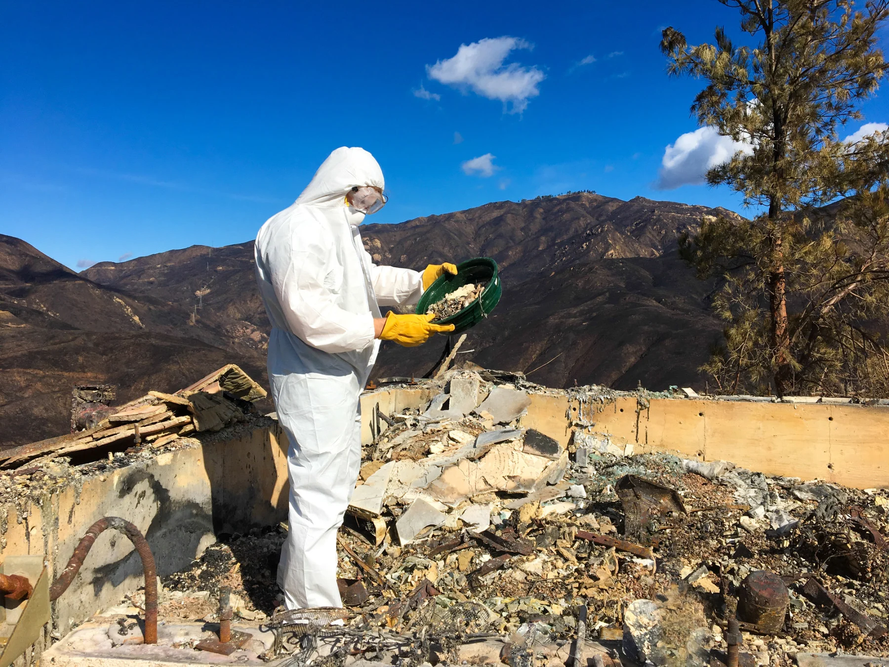 A man in hazmat suit sifts through ash and toxic waste after the Woolsey wildfire (2018) in Malibu, CA, USA.(JannHuizenga/ E+/ Getty Images)
