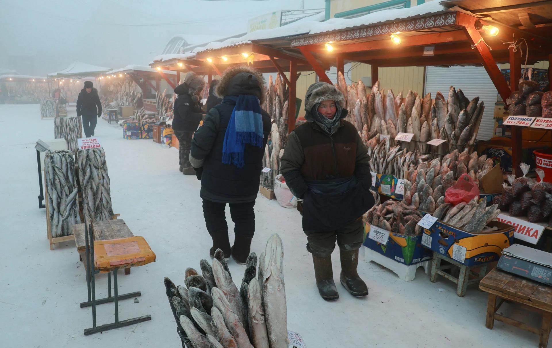 Reuters: Vendor Yegor Dyachkovsky stands next to deep-frozen fish at an open-air market on a frosty day in Yakutsk, Russia, December 5, 2023. Temperatures in parts of the Sakha Republic, also known as Yakutia and located in the northeastern part of Siberia, went below minus 50 degrees Celsius (minus 58 degrees Fahrenheit) on December 5. REUTERS/Roman Kutukov