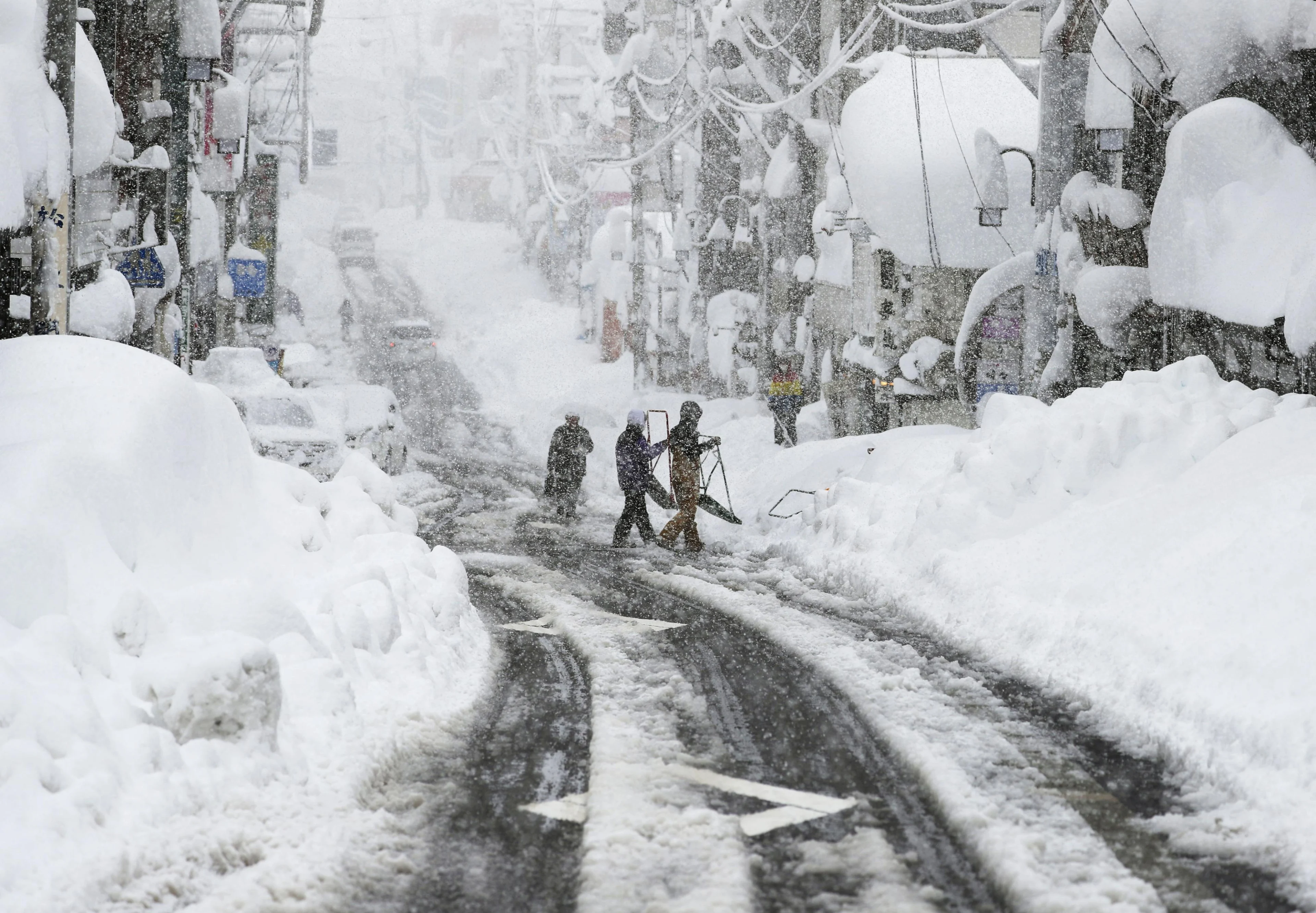 People remove snow on a street in Yuzawa, Niigata Prefecture, Japan in this photo taken by Kyodo December 17, 2020. Mandatory credit Kyodo/via REUTERS