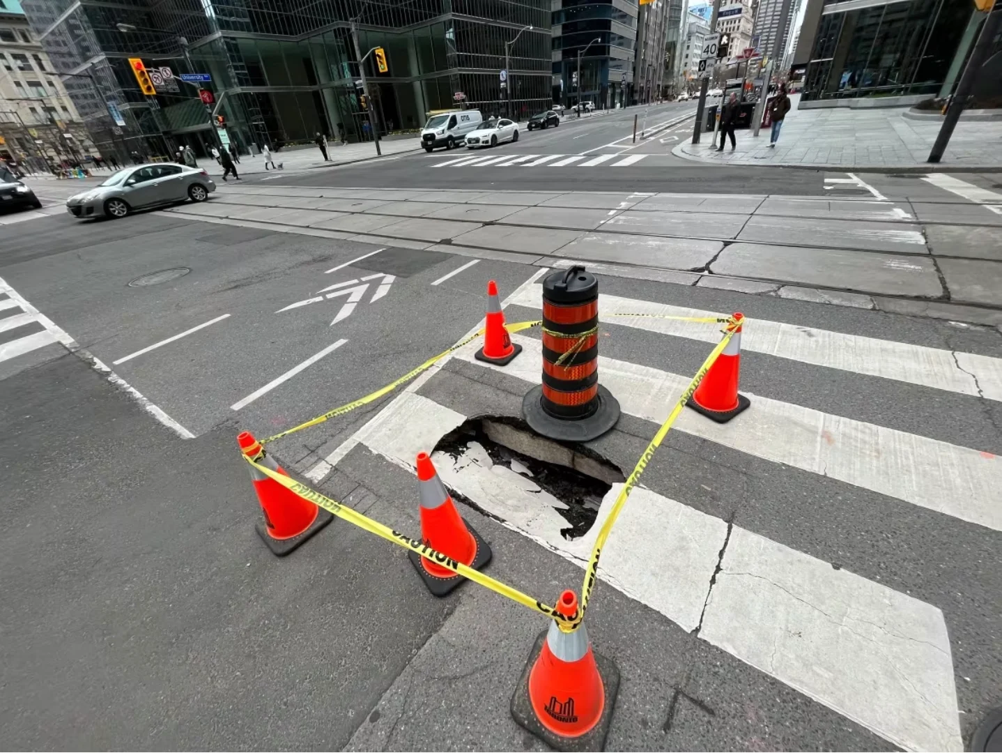 CBC: City of Toronto workers placed additional pilons around the sinkhole Tuesday as they prepared to fill it with gravel. (Ryan Patrick Jones/CBC)