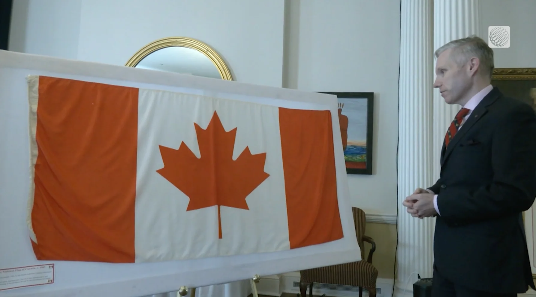 Christopher McCreery, Private Secretary & Executive Director of the Order of Nova Scotia observing one of the first 500 national flags made in Canada in January 1965, now housed in Halifax. (Photo credit: Nathan Coleman/The Weather Network)