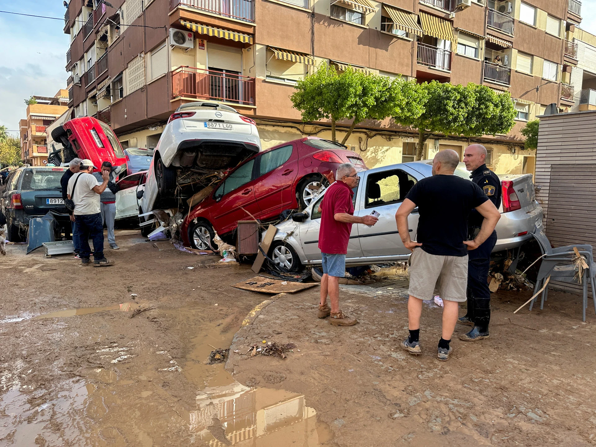 REUTERS: People stand alongside cars piled up on a residential street in the aftermath of torrential rains that caused flooding, in Alfafar, Valencia region, Spain October 31, 2024. REUTERS/Miguel Pereira